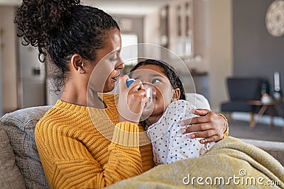 Lovely mother embracing daughter making inhalation with a nebulizer Stock Photo