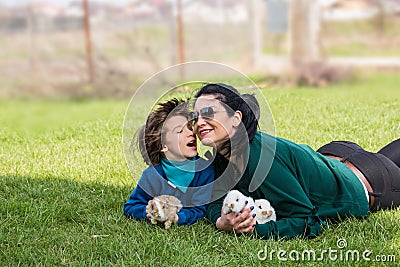 Lovely mother and son with bunnys in grass Stock Photo