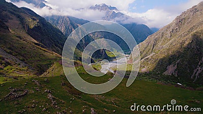 Lovely mountain scenery and sunshine peaking from behind the white clouds. Stock Photo