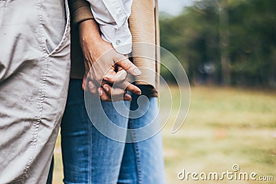 Lovely senior elderly smiling couple man and woman holding hand as promising of forever love or take care in romantic moment. Warm Stock Photo