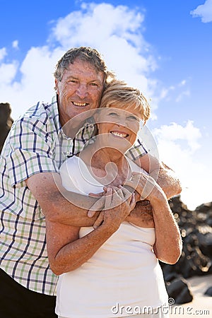 Lovely senior mature couple on their 60s or 70s retired walking happy and relaxed outdoors under a blue sky in love romantic aging Stock Photo