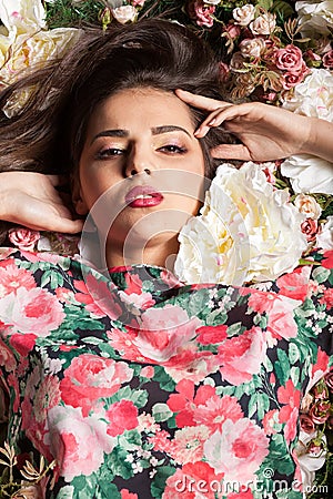 Lovely sensual woman lying on flowers Stock Photo
