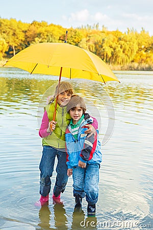 Lovely siblings under umbrella Stock Photo