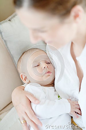 Lovely sleeping baby after breast feeding in mothers arms Stock Photo