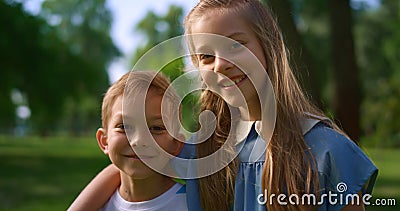 Lovely smiling siblings hugging in park. Preteen kids posing in park close up. Stock Photo