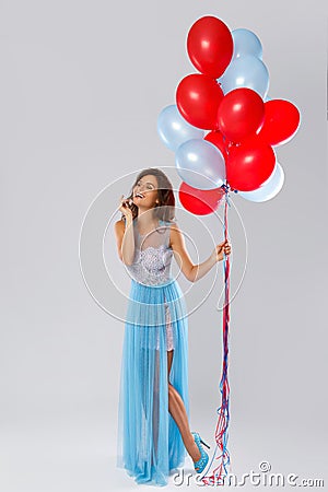 Woman wearing beautiful dress with a lot of colorful balloons Stock Photo