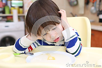 Lovely 2 years boy dont want to eat semolina porridge Stock Photo