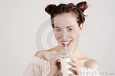 Lovely young girl is drinking with a straw with innocent smile on her face Stock Photo