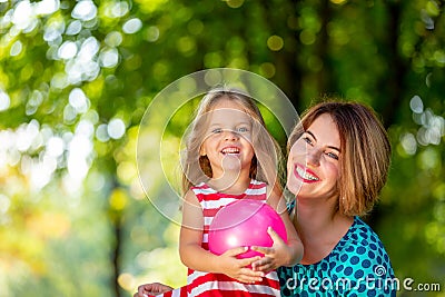 Lovely young mom and daughter in warm sunny summer day. Happy family mother and child little daughter playing and Stock Photo