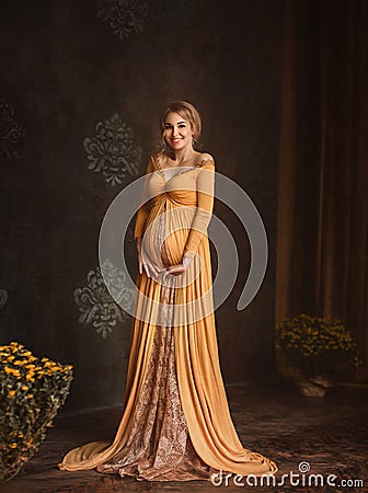 Lovely young pregnant woman in a beautiful dress Stock Photo