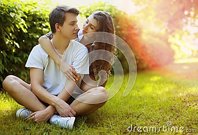 Lovely young teen couple in love having fun on lawn in park Stock Photo