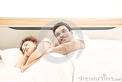 Lover concept. Young attractive couple lying under white blanket in bed Stock Photo