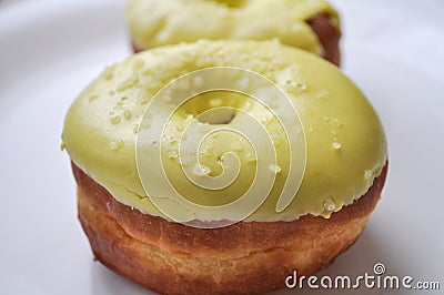Yellow glazed donut on a plate. sweet dessert. Stock Photo