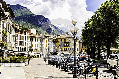 LOVERE, ITALY, June 30, 2017: Cozy street with houses, parked motorcycles against the background of beautiful mountains and Editorial Stock Photo