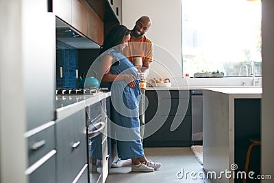 Loving African American Husband With Pregnant Wife At Home In Kitchen Together Stock Photo