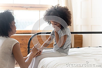 Loving biracial mom caress comfort sad little daughter Stock Photo