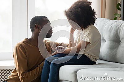 Loving african dad comforting crying kid daughter showing empathy Stock Photo