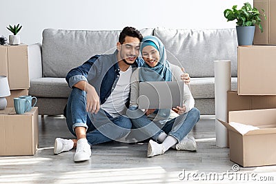 Loving arab family using laptop at new apartment Stock Photo