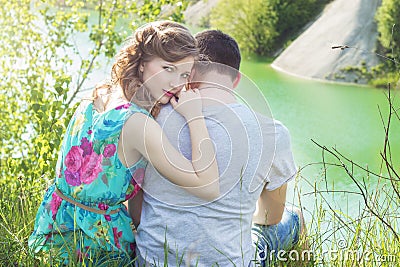 Loving beautiful couple of guys and girls in the field walking man kissing the girls forehead Stock Photo