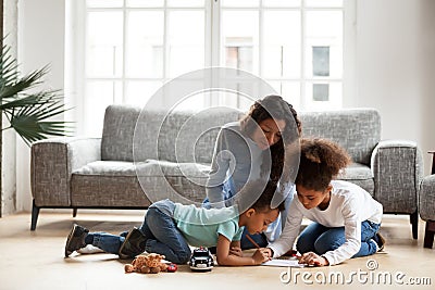 Loving black mom and little children drawing with colored pencil Stock Photo