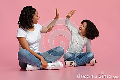 Loving Black Mother And Daughter Giving High Five To Each Other Stock Photo