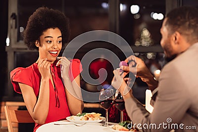 Loving Boyfriend Asking Surprised Girlfriend To Marry Him In Restaurant Stock Photo