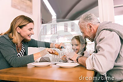 Loving caring grandparents giving their little girl fresh croissant Stock Photo