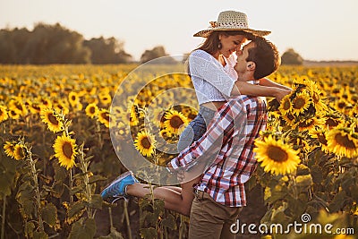 Loving couple in a blooming sunflower field Stock Photo