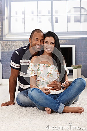 Loving couple embracing at home smiling Stock Photo