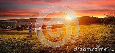 Loving couple holding hands running on the field. Stock Photo