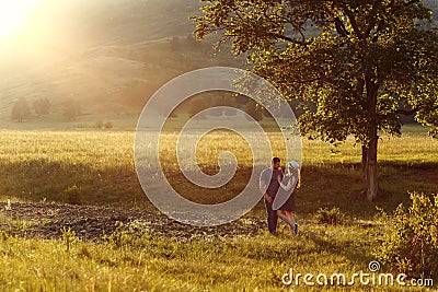 Loving couple hugging, honeymoon in the mountains, the landscape, the warm colours of the setting sun, backlight, mountains, summe Stock Photo