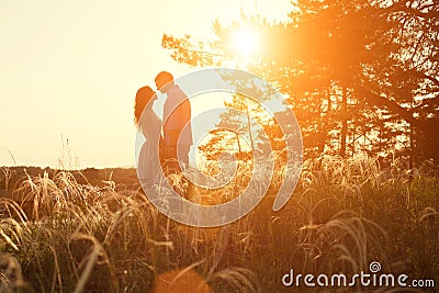 Loving couple kissing at sunset Stock Photo