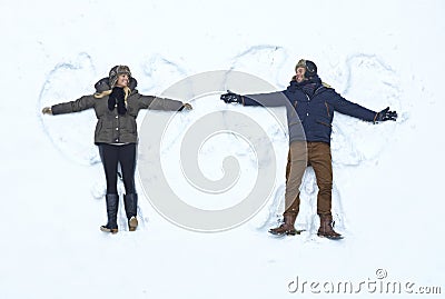 Loving couple making snow angel Stock Photo