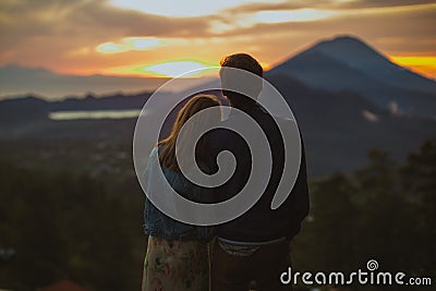 A loving couple, a man and a woman stands near Batur volcano. Sunrise, sunset Editorial Stock Photo