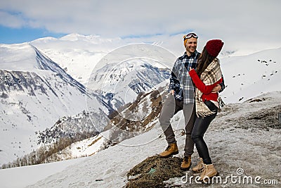 A loving couple plays together in the snow outdoors. Winter holidays in the mountains. Stock Photo