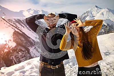 A loving couple plays together in the snow outdoors. Winter holidays in the mountains. Stock Photo