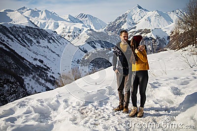 A loving couple plays together in the snow outdoors. Winter holidays in the mountains. Stock Photo