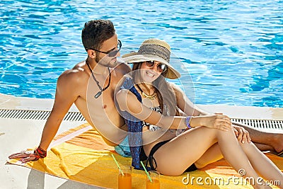 Loving couple relaxing in the sun at the pool. Stock Photo