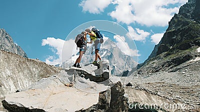 Loving couple of tourists with backpacks in the hike kiss on the top in the mountains. The concept of love, achievement Stock Photo