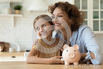 Dreamy mom and small child saving money for future vacation Stock Photo