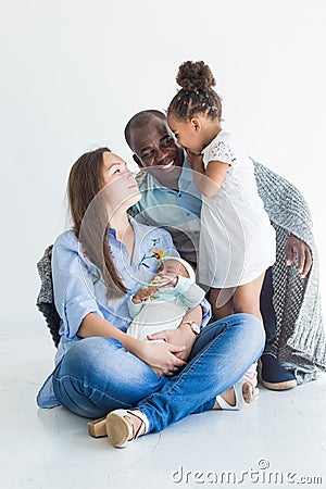 Loving father covers his family with a plaid. Happy multiethnic family. Family values Stock Photo