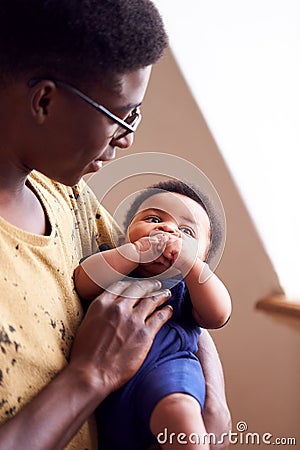 Loving Father Holding Newborn Baby At Home In Loft Apartment Stock Photo