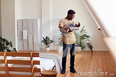 Loving Father Holding Newborn Baby At Home In Loft Apartment Stock Photo