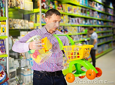 Father choosing playthings in toy store Stock Photo