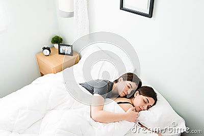 Loving girlfriends sleeping in a big comfortable bed Stock Photo