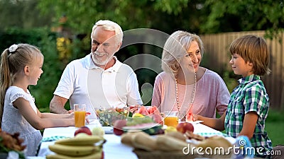 Loving grandchildren visiting grandparents, happy senior couple admiring kids Stock Photo