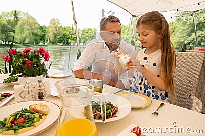 Loving grandfather watching his cute girl eating bruschetta Stock Photo