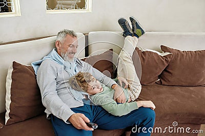 Loving grandpa. Portrait of a happy grandfather and excited grandson embracing, having fun and playing while relaxing on Stock Photo