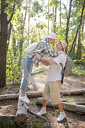 Loving grey-haired wife hugging her handsome man Stock Photo