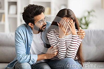 Loving husband indian man comforting consoling upset crying wife Stock Photo